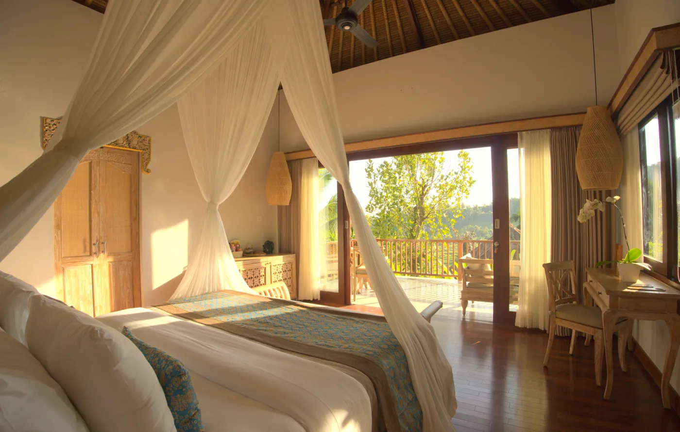 Bedroom with a canopy bed and sliding doors open to a terrace