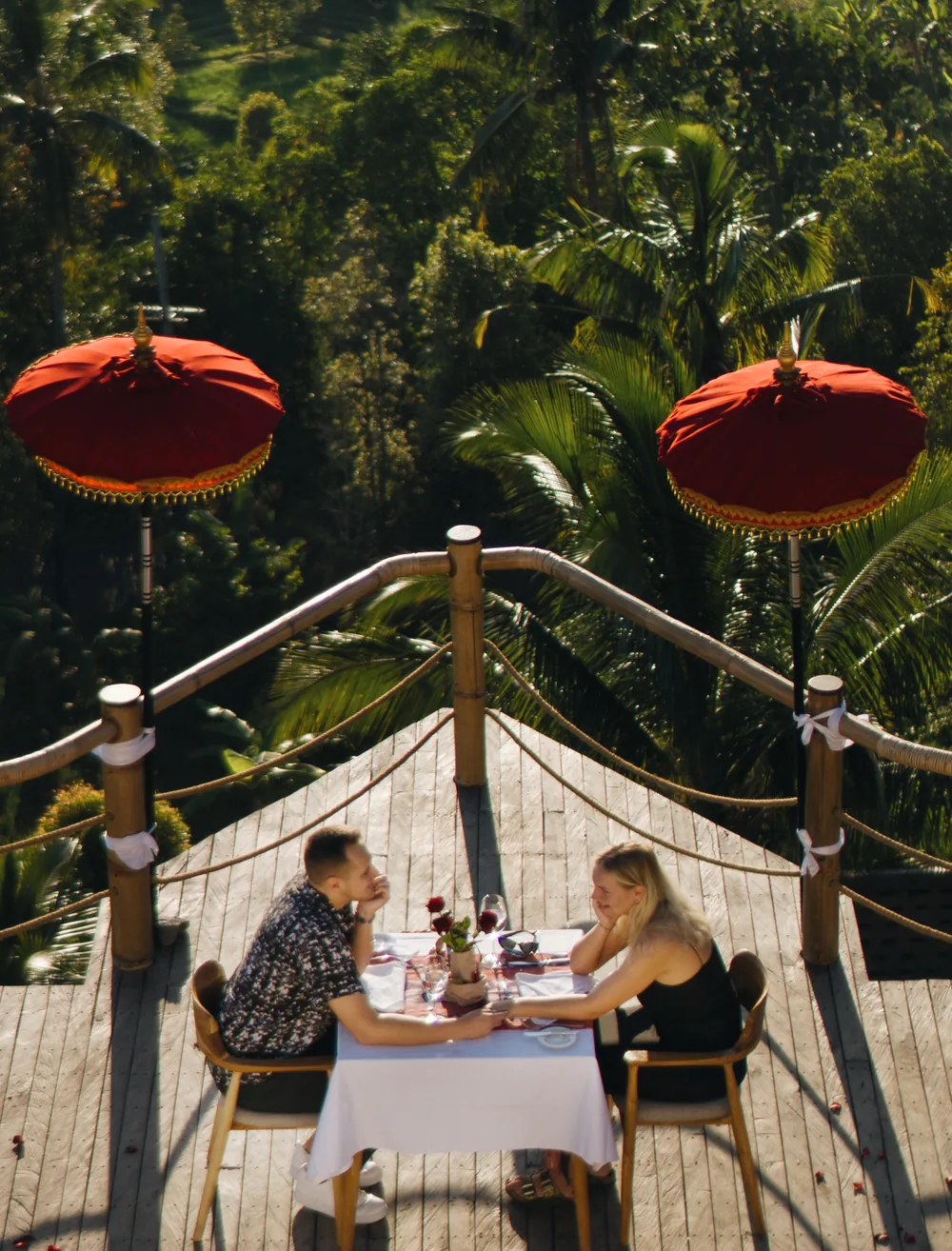 Couple dining on a terrace above rice fields
