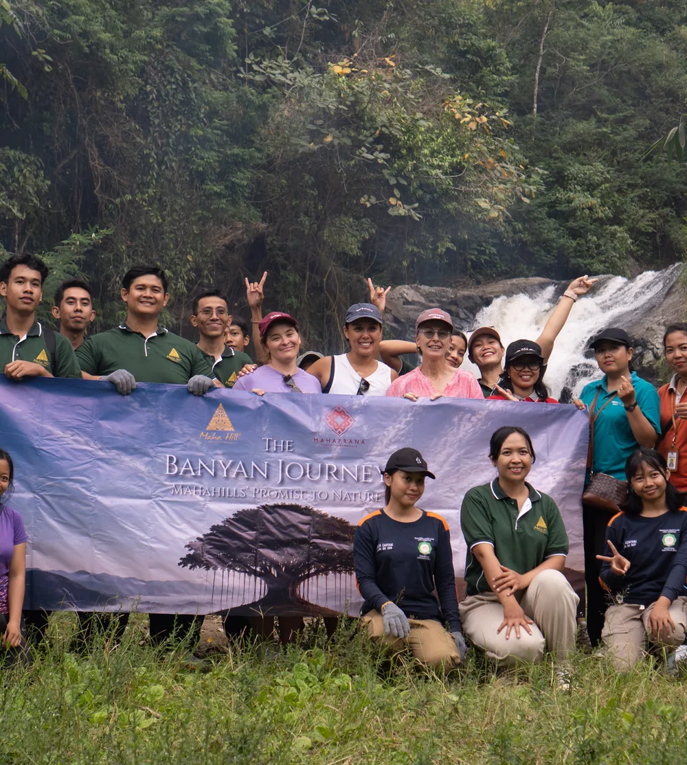 Group of people holding a banner beside a waterfall