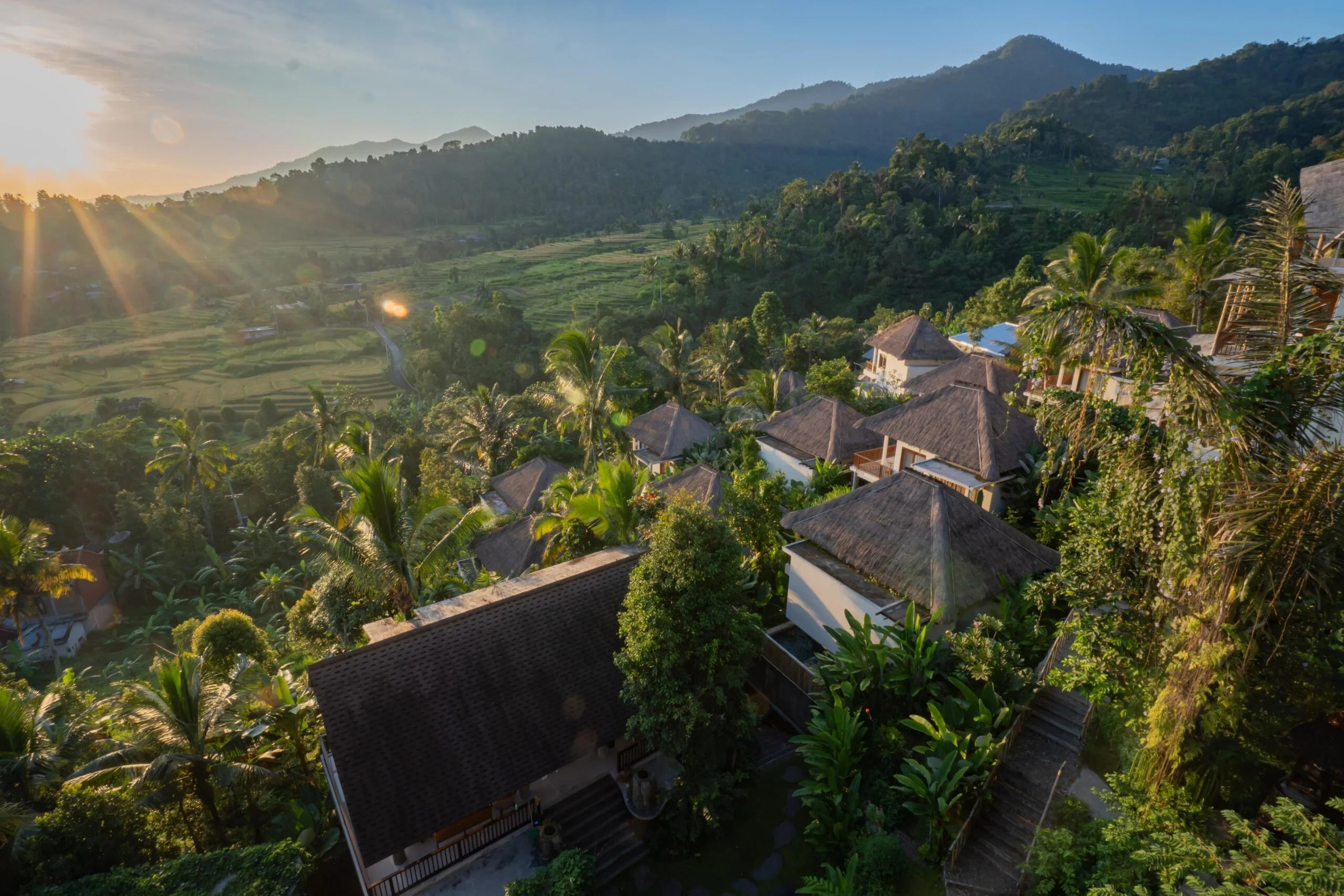 Sunrise over terraced rice fields and thatched-roof villas in the hills of Sambangan, North Bali